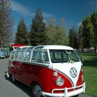 Pink vintage Volkswagen van in snowy landscape with evergreen trees under starry night sky