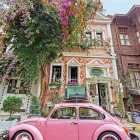 Pink vintage car watercolor illustration on quaint street with blossoming trees.