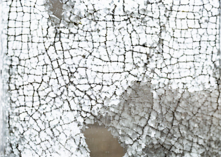 Weathered surface with cracked white paint showcasing intricate lines and textures