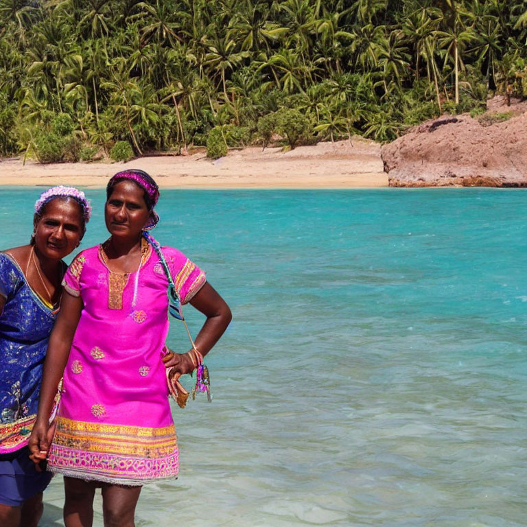 Two Women Standing in Shallow Beach Water with Tropical Trees