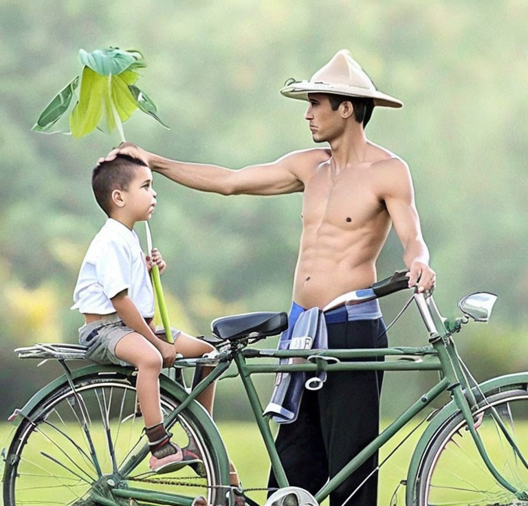 Shirtless man with hat next to green bicycle and child with leaf on head