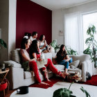 Three People Sorting Items in Room with Red Wall