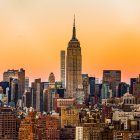 Cityscape Collage with Various Buildings and Tower Against Fiery Sky