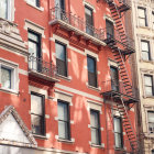 Sunlit vibrant red European-style building with white trim and balconies