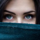 Detailed Close-Up of Woman's Blue Eyes Above Water with Droplets