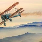 Vintage Biplane Soaring Over Mountainous Sunset Landscape