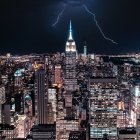 Nighttime cityscape with illuminated skyscrapers and lightning striking.