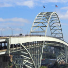 Futuristic bridge with people over industrial landscape