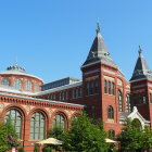 Classic red-brick building with ornate towers against blue sky