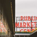 Colorful ornate staircase and "Public Market" sign against cloudy sky showcase urban contrasts.