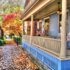 Vibrant autumn illustration of a blue house with people and fall foliage