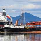 Harbor scene: Fishing boats, misty mountains, clear sky