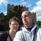 Man and woman in historical attire with castle backdrop and starry sky.