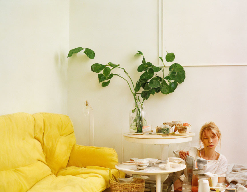 Cozy room with breakfast remnants, yellow couch, and green plant