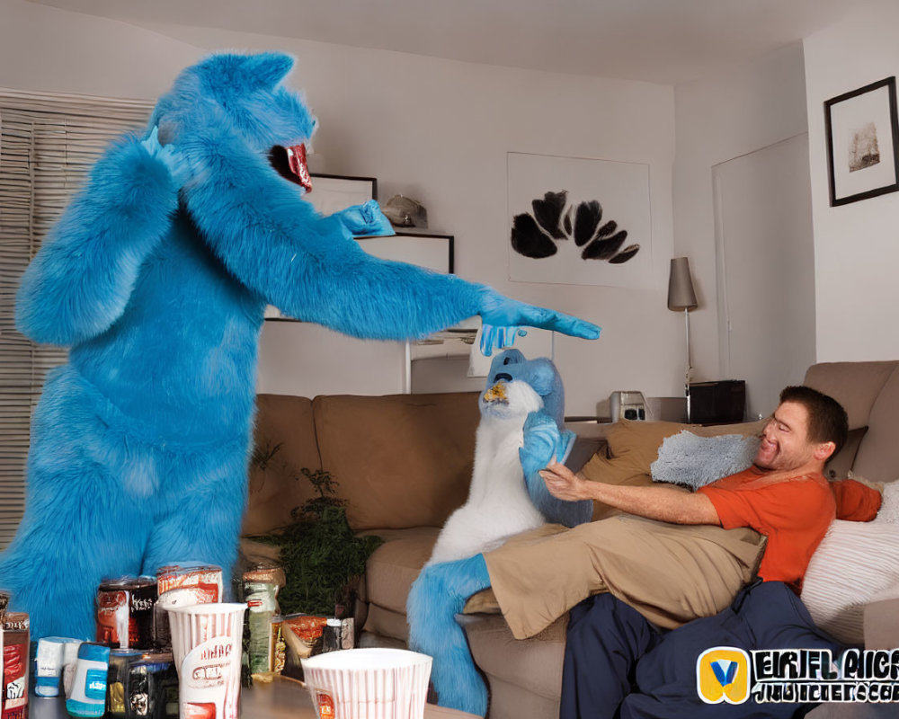 Blue monster costume person high-fives puppeteer by couch with snacks