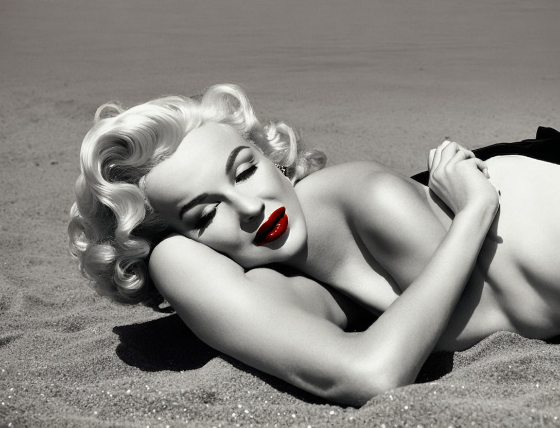 Monochrome image: Woman with platinum blonde hair and red lipstick on sandy beach