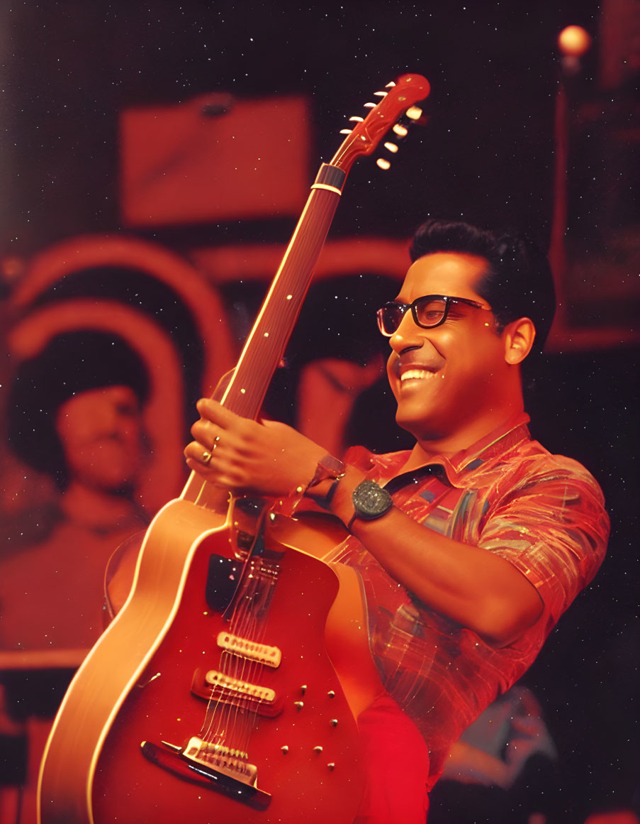 Smiling man with electric guitar on stage with band in warm lighting