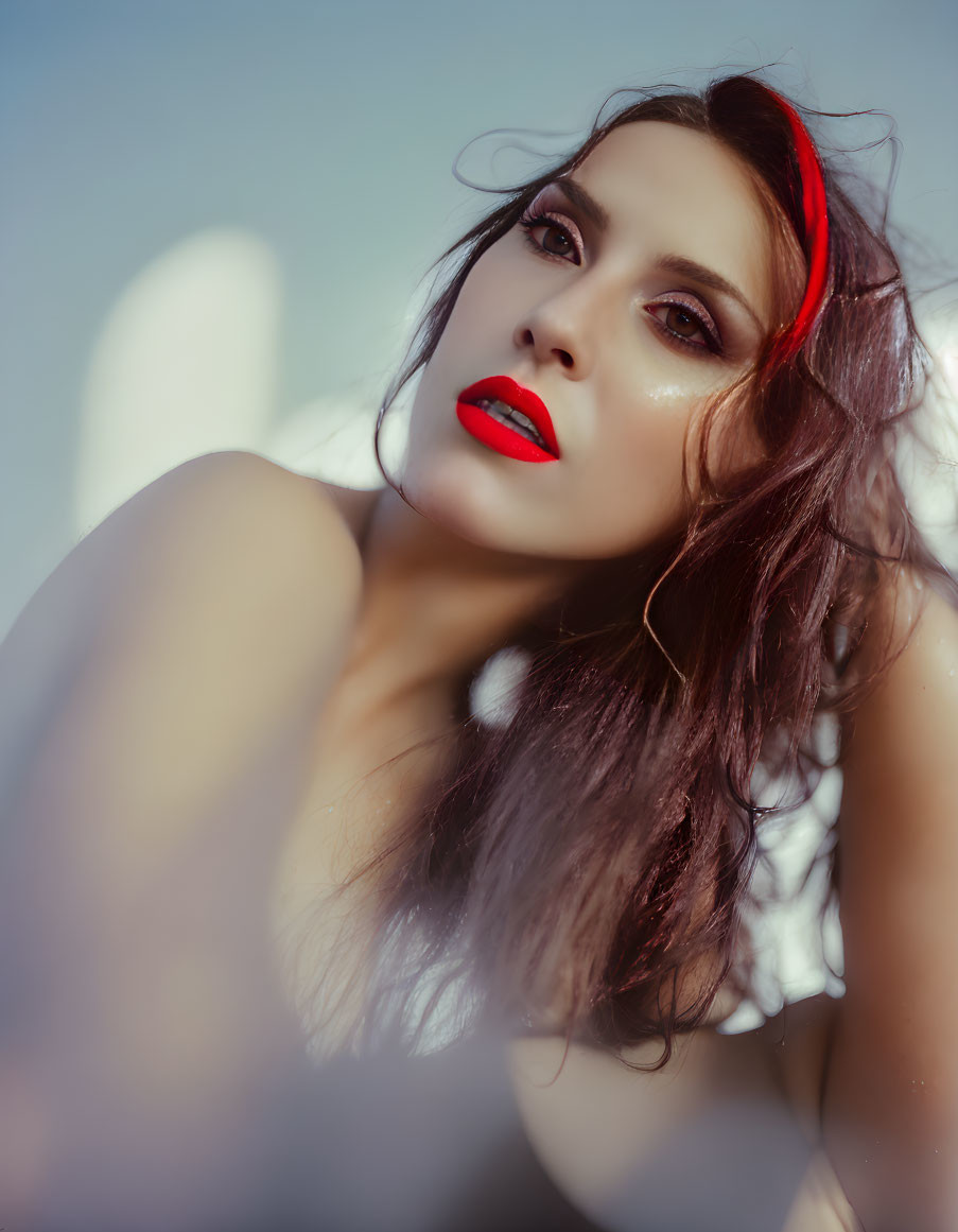 Woman with red lipstick and headband in soft-focus background