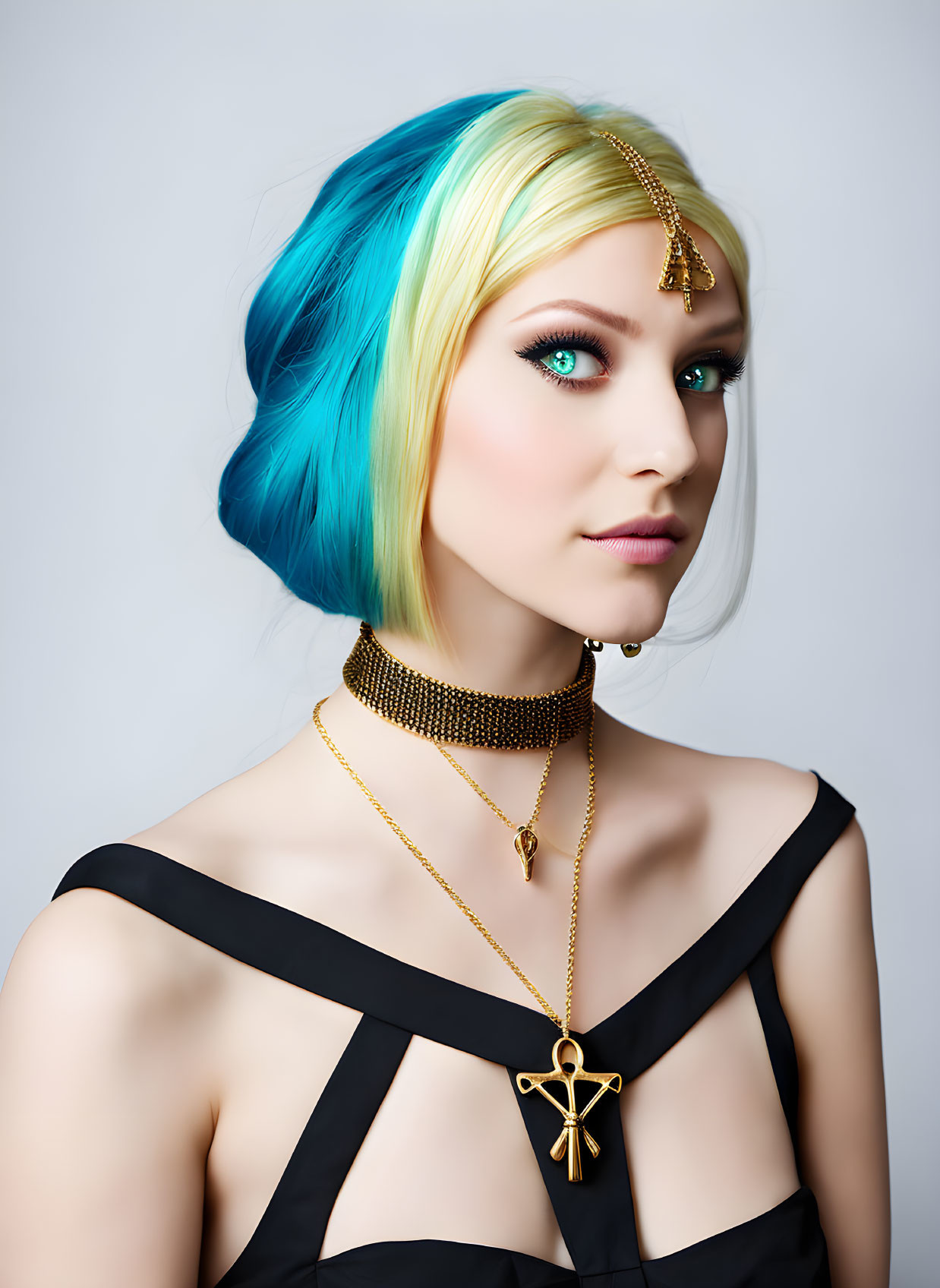 Portrait of woman with vibrant blue and yellow hair and striking blue eyes in black dress