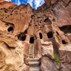 Multi-level dome-shaped building in red sandstone cliffs