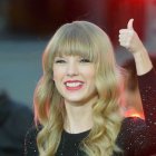 Blonde woman in sequined top with red lipstick and thumbs up