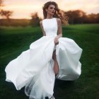 Elaborate fantasy dress woman on rocky beach at sunset