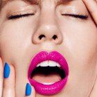 Person with Pink Lips, Blue Nails, and Egg Yolk on Face