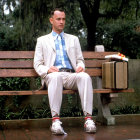 Clown in costume with prop gun and puppet on park bench