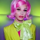 Futuristic female android with pink hair in yellow suit on neon green background