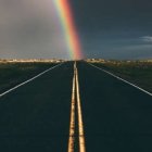 Colorful Rainbow Over Road with Illuminated Dots and Wildflowers