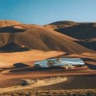 Futuristic silver building in sand dunes under blue sky