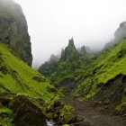 Tranquil landscape with monks on wooden bridge in misty hills