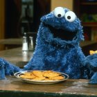 Blue Cookie Monster Surrounded by Cookies and Small Monsters