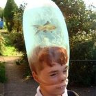 Woman with glasses using large lens-shaped glass in mechanical contraption outdoors