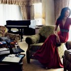 Elegant women in red gowns on classic white sofas in luxurious room