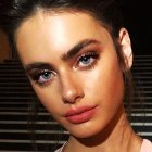 Woman with Striking Blue Eye Makeup and Freckles in Sunlight Shadow Patterns