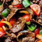 Assorted Raw Steak Cuts with Colorful Vegetables on Wooden Surface