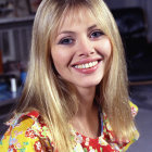 Smiling woman with blue eyes in floral outfit on blurred background