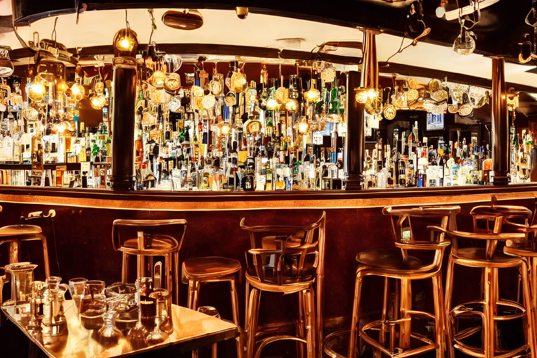 Cozy bar interior with wooden counter, shelves of bottles, beer handles, high stools, and warm