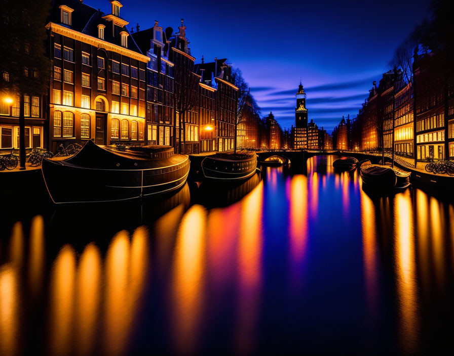 Tranquil Amsterdam canal at twilight with illuminated buildings and moored boats