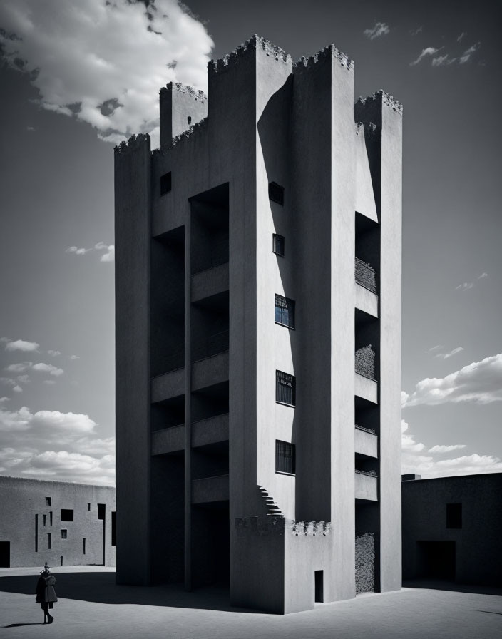 Monochrome image of tall, narrow building with cutouts under cloudy sky