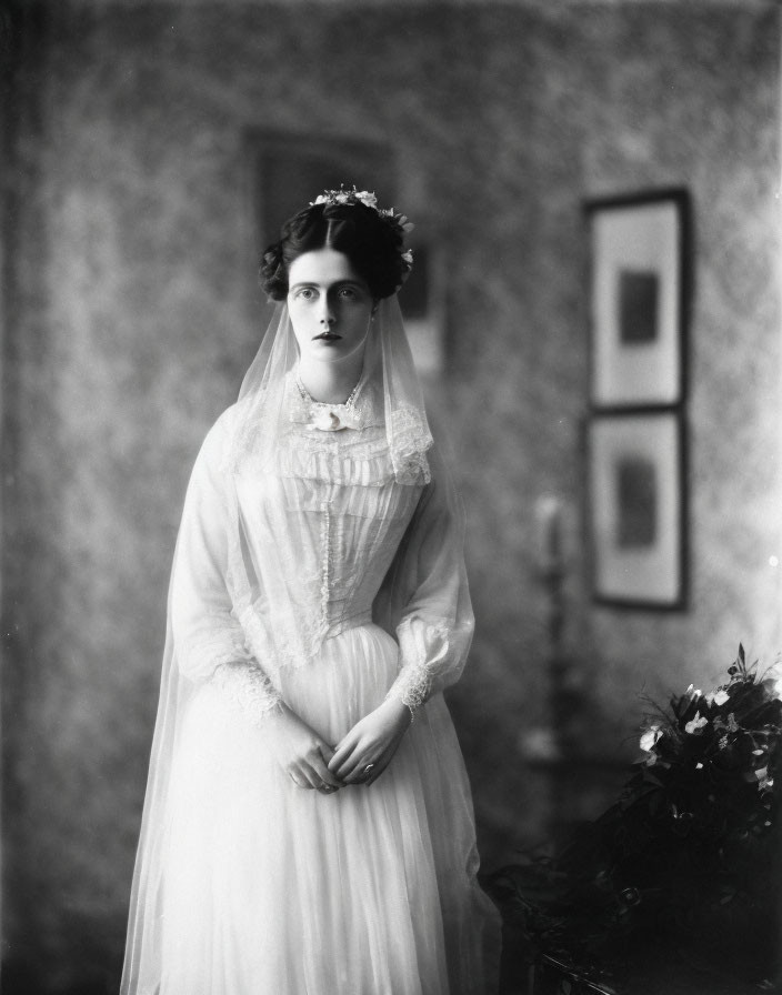 Vintage Black-and-White Photo: Woman in Wedding Dress with Veil and Bouquet