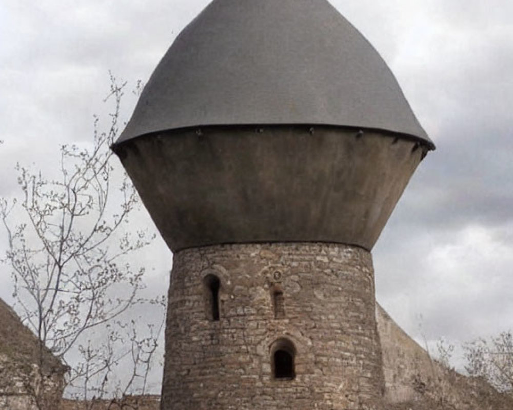 Stone conical-roofed tower with arched openings in a serene historical setting