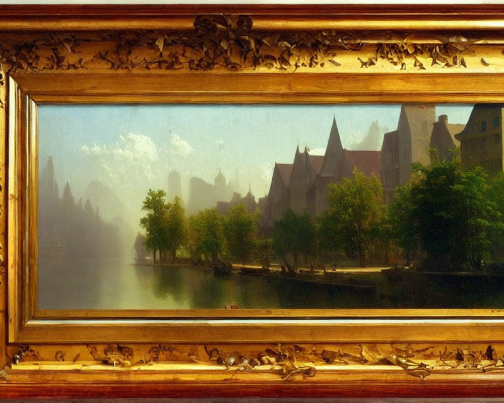 Gilded picture frame with serene river landscape and European buildings.