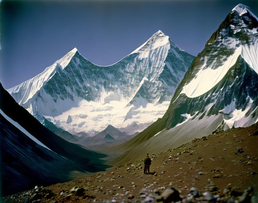 Hiker in stark mountain landscape with snow-capped peaks