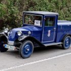 Classic Blue Car on Tree-Lined Path with Figure in Red - Impressionist Style