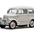 Vintage car illustration: monochrome side profile view with rounded hood and large fenders