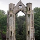 Surreal image of ancient arches against green trees