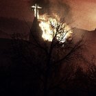 Gothic church in fiery forest with illuminated windows