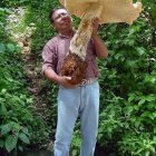 Smiling man with large mushroom in forest setting